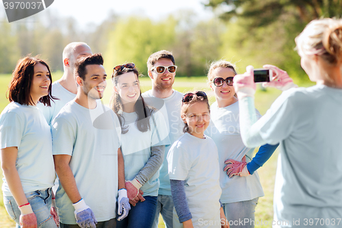 Image of group of volunteers taking picture by smartphone