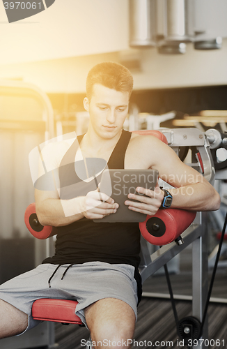 Image of young man with tablet pc computer in gym