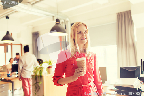 Image of happy creative female office worker with coffe cup