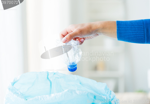 Image of close up of hand and used bottles in rubbish bag