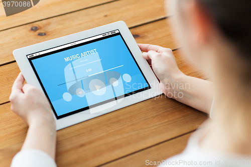 Image of close up of woman with tablet pc on wooden table