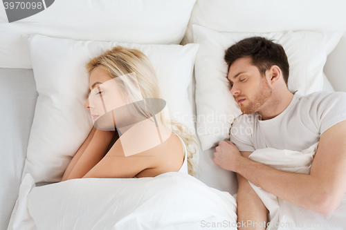 Image of happy couple sleeping in bed at home