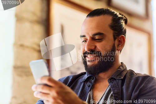 Image of man with smartphone at bar or pub