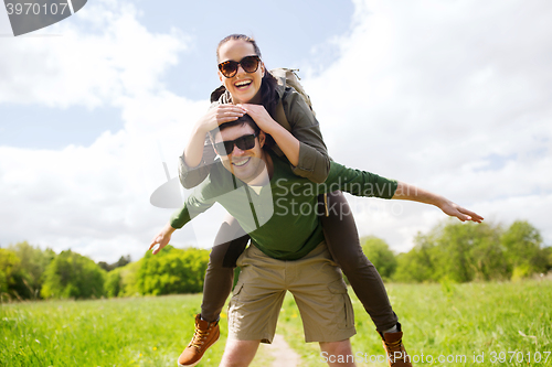 Image of happy couple with backpacks having fun outdoors