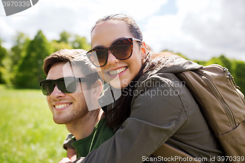 Image of happy couple with backpacks having fun outdoors