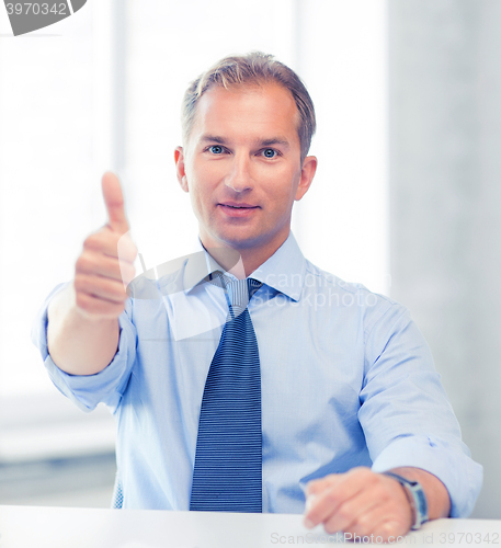 Image of smiling businessman showing thumbs up