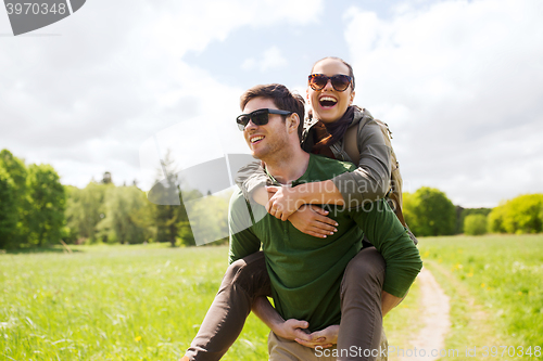 Image of happy couple with backpacks having fun outdoors