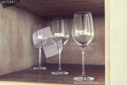 Image of empty wine glasses set on shelf at restaurant