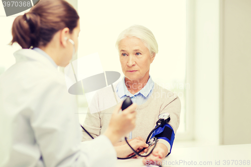 Image of doctor with tonometer and senior woman at hospital