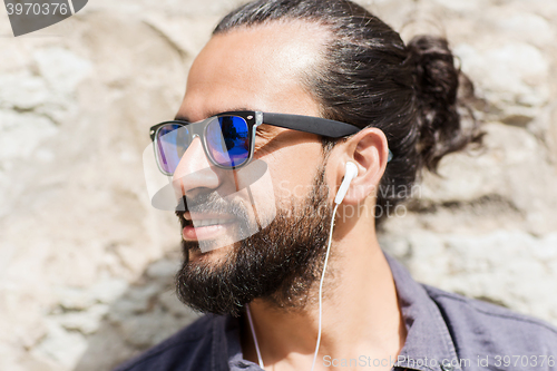 Image of happy man with earphones listening to music