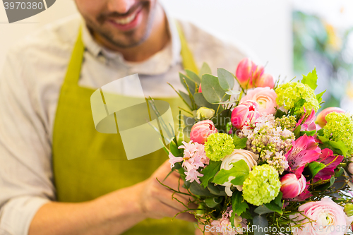 Image of close up of florist man with bunch at flower shop