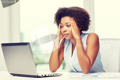 Image of african woman with laptop at office