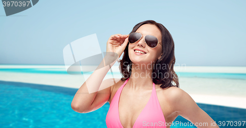 Image of happy woman in sunglasses and bikini on beach