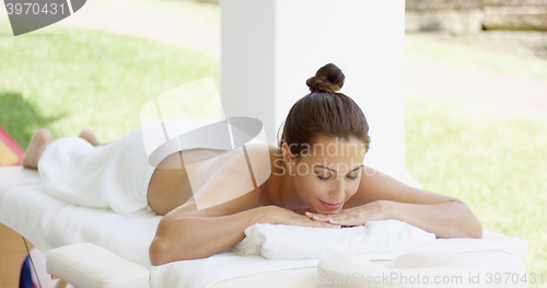 Image of Tranquil spa customer relaxes on table