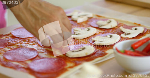 Image of Woman making a delicious pepperoni pizza