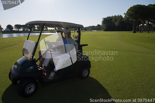 Image of golf players driving cart at course