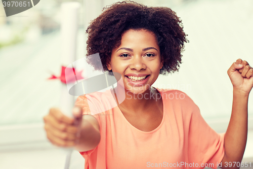 Image of happy african american woman with diploma at home
