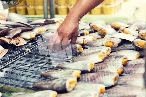 Image of close up of hand taking fish at street market