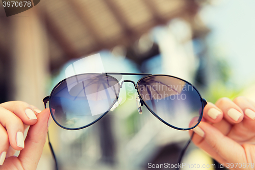 Image of close up of hands holding shades or sunglasses
