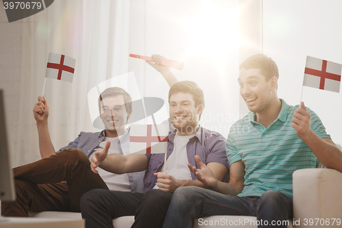 Image of happy male friends with flags and vuvuzela