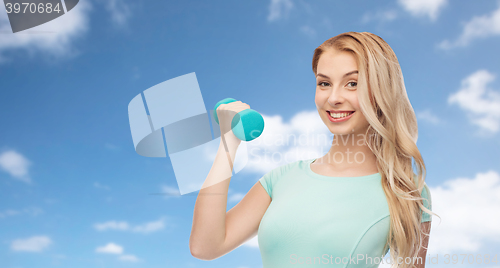 Image of smiling beautiful young sporty woman with dumbbell