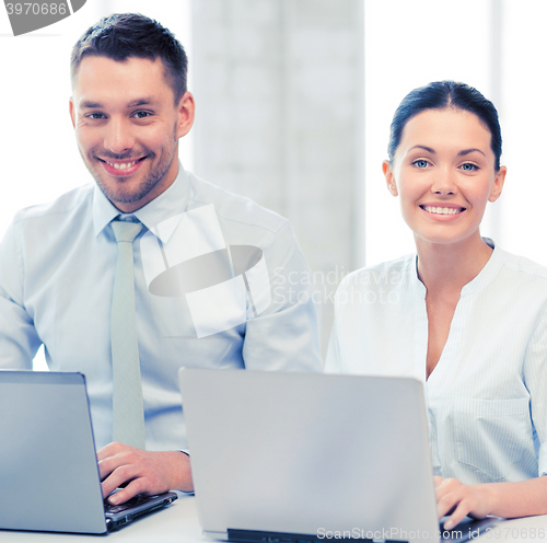 Image of group of people working with laptops in office