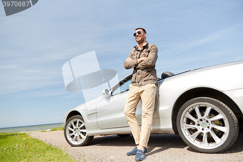 Image of happy man near cabriolet car outdoors