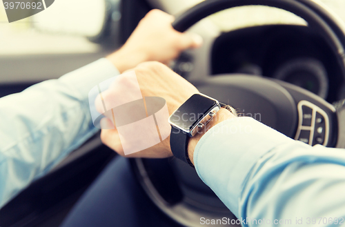 Image of close up of man with wristwatch driving car