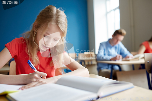 Image of student girl with book writing school test