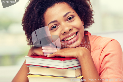 Image of happy african student girl with books at home