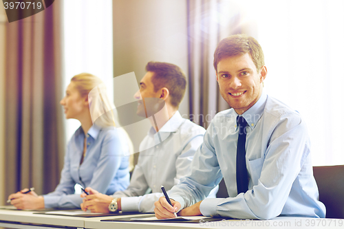 Image of group of smiling businesspeople meeting in office