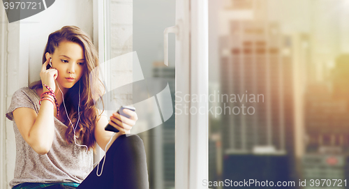 Image of teenage girl with smartphone and earphones