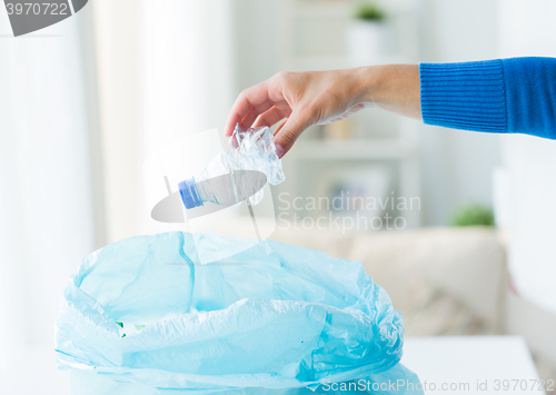 Image of close up of hand and used bottles in rubbish bag