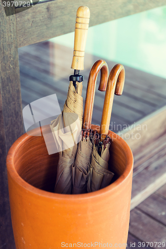 Image of vase with umbrellas on terrace at hotel or home