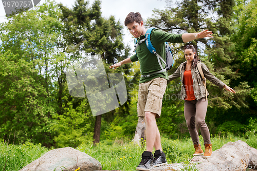 Image of happy couple with backpacks hiking outdoors