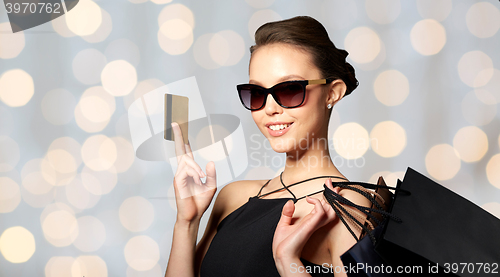 Image of happy woman with credit card and shopping bags