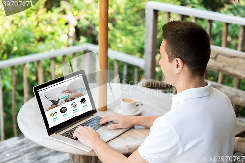 Image of close up of man with online shop page on laptop