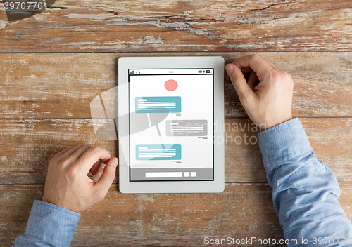 Image of close up of male hands to tablet pc on table