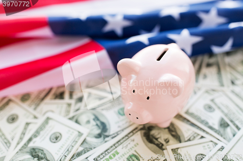 Image of close up of american flag, piggy bank and money