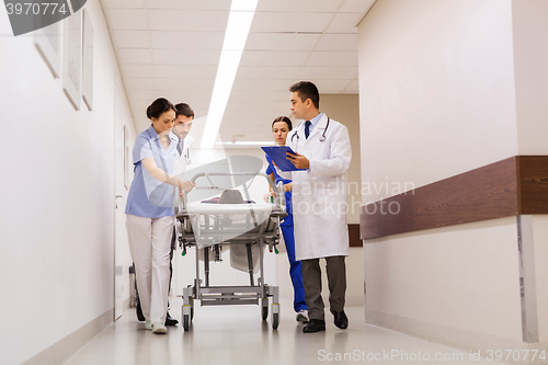 Image of medics with woman on hospital gurney at emergency