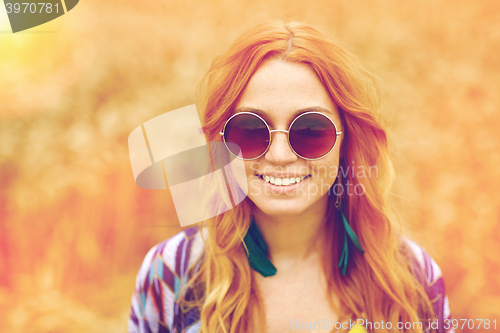 Image of smiling young redhead hippie woman outdoors