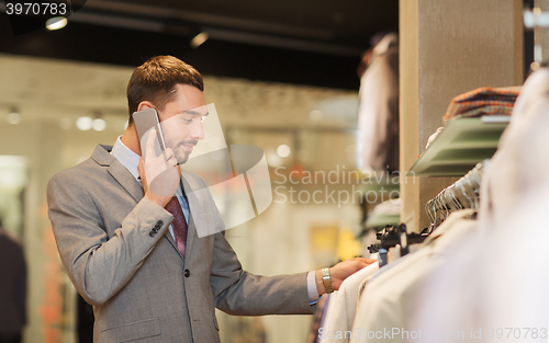Image of happy man calling on smartphone at clothing store