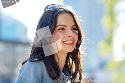 Image of happy smiling young woman on summer city street