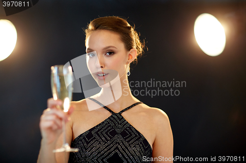 Image of young asian woman drinking champagne at party