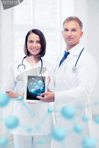 Image of two doctors showing tablet pc with molecules