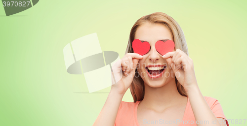Image of happy young woman with red heart shapes on eyes