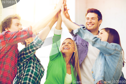 Image of happy students giving high five at school