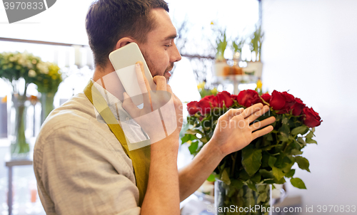 Image of man with smartphone and red roses at flower shop