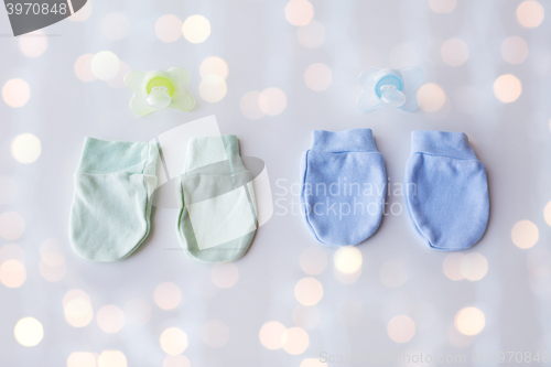 Image of close up of baby mittens and soothers for twins