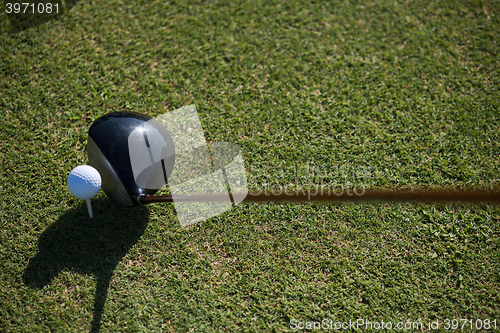 Image of top view of golf club and ball in grass